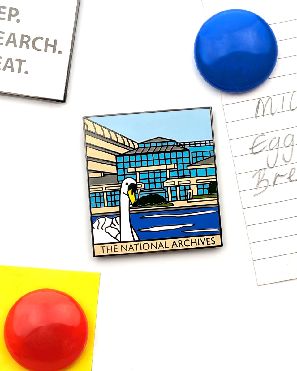 An enamel magnet featuring an illustration of The National Archives building with a white swan in the foreground, displayed on a white background with pins and paper props.