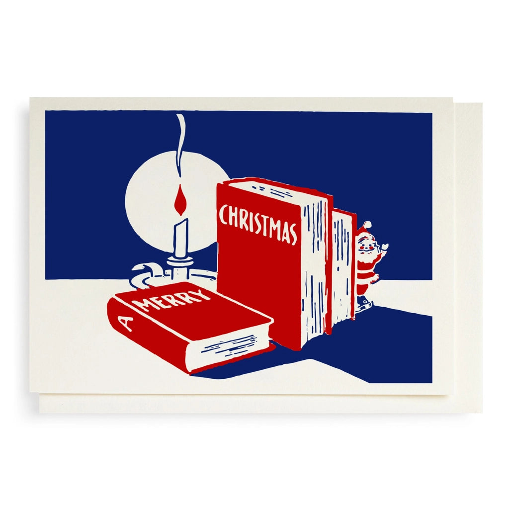 Festive card with books titled 'A Merry Christmas' and a candle on a blue background.