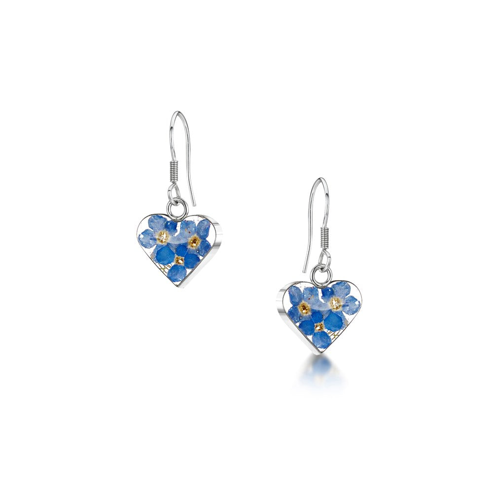 A pair of silver heart-shaped drop earrings featuring blue forget-me-not flowers with gold centres, shown on a white background.