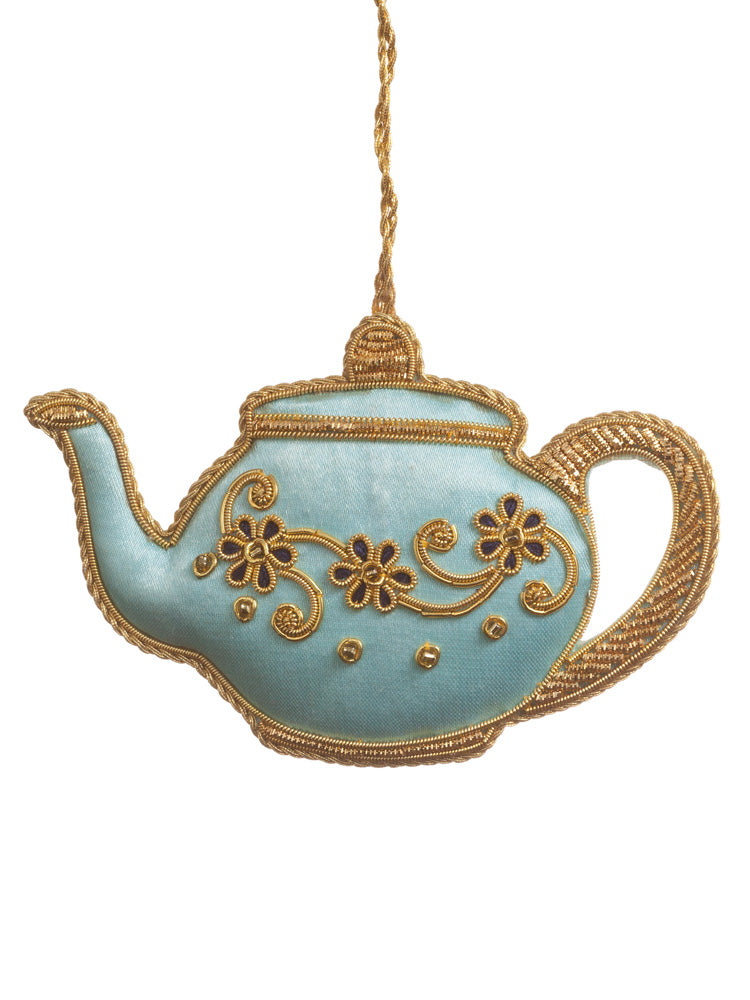 Decorative fabric teapot ornament with gold accents on a white background