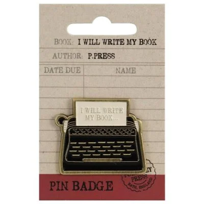 Enamel typewriter shaped pin badge on backing card