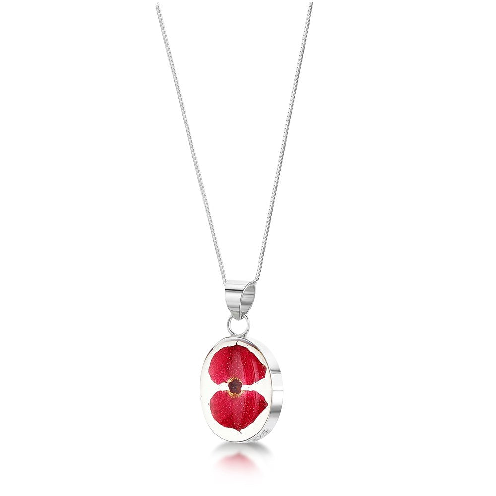 Silver necklace with a pendant featuring a red pressed poppy flower encased in clear resin.