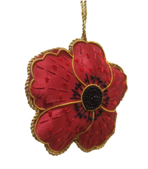 A double-sided red poppy decoration with the years 1914-1918 written on the reverse side, handmade using metal and silk threads on a satin background.